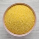 Organic Masarepa corn meal in a pink bowl over white wooden back Organic Masarepa corn meal in a pink bowl over white wooden background, top view. Overhead, from above. Closeup.